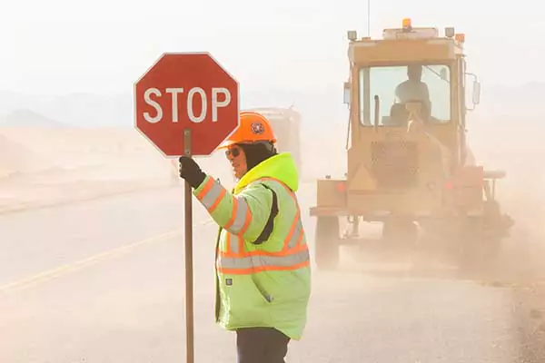 worker holding a stop sign board